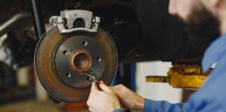 Czy warto kupować zestawy naprawcze zamiast całych części przykłady z zacisków hamulcowych pomp i przekładni Mechanik naprawiający tarczę hamulcową w warsztacie samochodowym