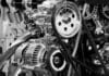 Alternator nie ładuje akumulatora – naprawa, regeneracja czy wymiana? Zbliżenie na metalowe elementy silnika samochodowego w czerni i bieli
