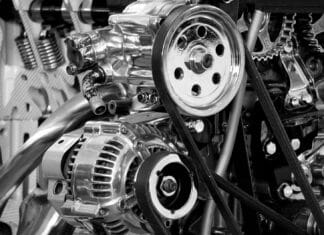 Alternator nie ładuje akumulatora – naprawa, regeneracja czy wymiana? Zbliżenie na metalowe elementy silnika samochodowego w czerni i bieli