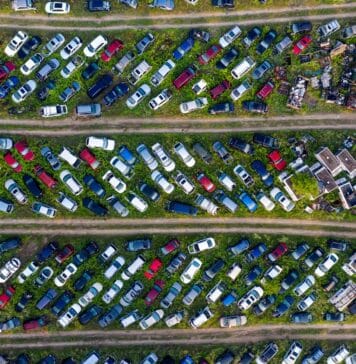 Widok z góry na złomowisko z rzędami porzuconych samochodów