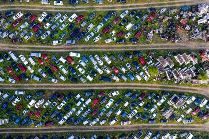 Widok z góry na złomowisko z rzędami porzuconych samochodów